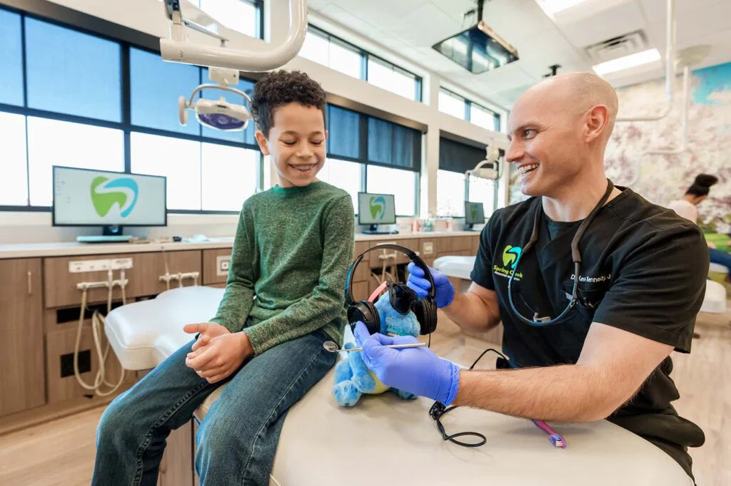 Young boy with dentist stuffed animal listening to headphones