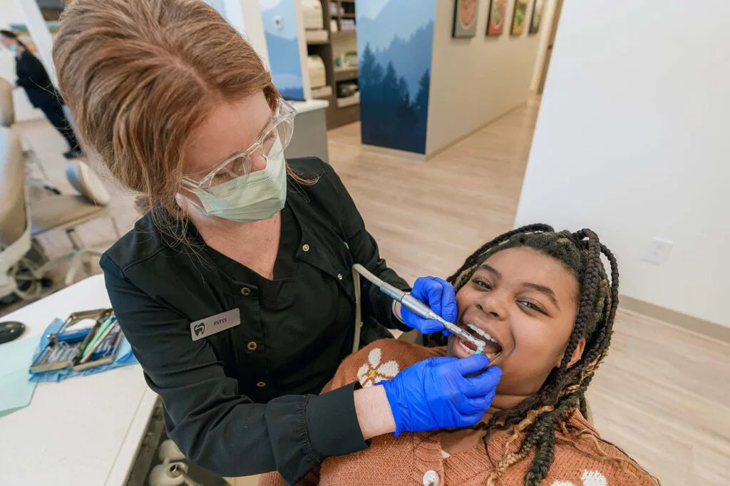 Teen smiling getting teeth worked on