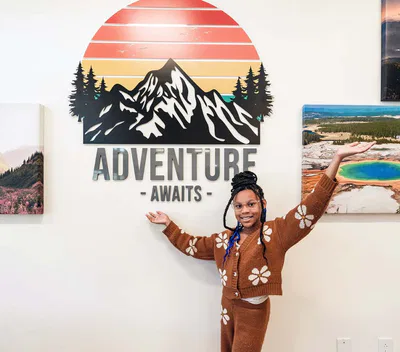 Young girl in front of adventure awaits sign